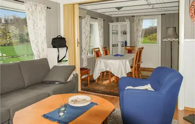 a living room with a couch and a table and chairs at 3 Bedroom Awesome Home In Skjold in Skjold