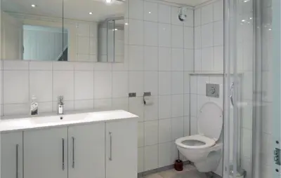 a bathroom with a toilet and a sink and a shower at 3 Bedroom Awesome Home In Skjold in Skjold
