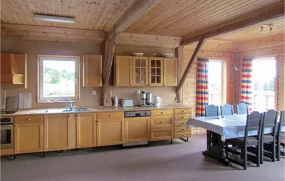 a kitchen with wooden cabinets and a table with chairs at Holiday Home Bjoa Haugsgjerdet in Utbjoa