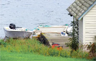 a boat parked next to a house next to the water at Holiday Home Bjoa Haugsgjerdet in Utbjoa