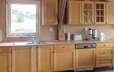 a kitchen with wooden cabinets and a sink and a window at Holiday Home Bjoa Haugsgjerdet in Utbjoa