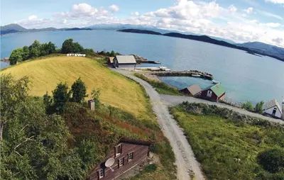 a house on a hill next to a body of water at 3 Bedroom Gorgeous Home In Bjoa in Utbjoa