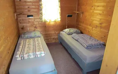 two twin beds in a cabin with a window at 3 Bedroom Gorgeous Home In Bjoa in Utbjoa