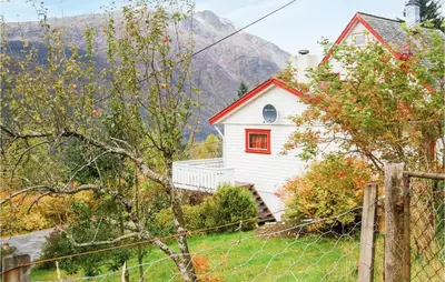 a white house with a red window and a fence at Ytre Matre in Hamre