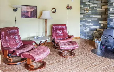 a living room with two chairs and a table at Ytre Matre in Hamre