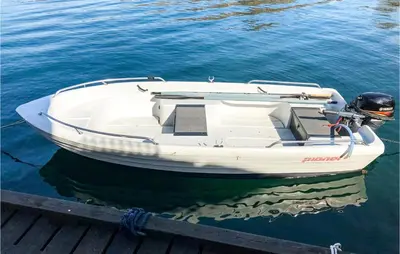 a white boat sitting on the water at a dock at Kyrping Ferieplass A in Erve