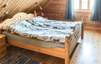 a bedroom with two beds in a wooden room at Kyrping Ferieplass A in Erve