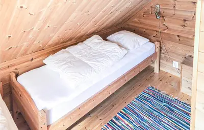 a wooden room with a bed in a wooden cabin at Kyrping Ferieplass A in Erve
