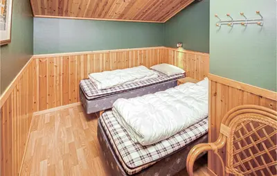 two beds in a room with wood paneling at Amazing Home In Auklandshamn With Sauna in Vestvik