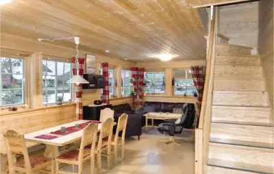 a living room with a wooden ceiling and a table and chairs at Vågen 1 in Åkra