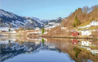 a reflection of houses and mountains in a river at Gorgeous Home In Åkra With Wifi in Åkra