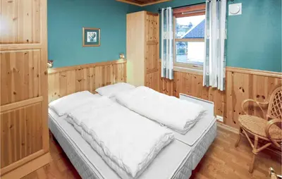 a bedroom with a bed and a window at 4 Bedroom Cozy Home In Auklandshamn in Vestvik