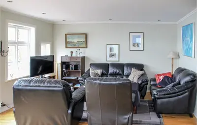 a living room with leather furniture and a flat screen tv at Galanten in Grimsland