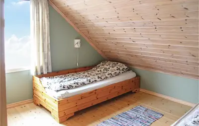 a bed in a room with a wooden wall at Galanten in Grimsland