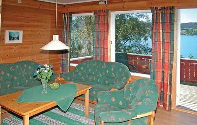 a living room with two chairs and a table at Nice Home In Sandvoll in Sandvoll