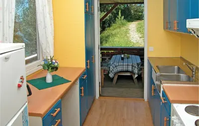 a small kitchen with a table and a sink and a table at Nice Home In Sandvoll in Sandvoll