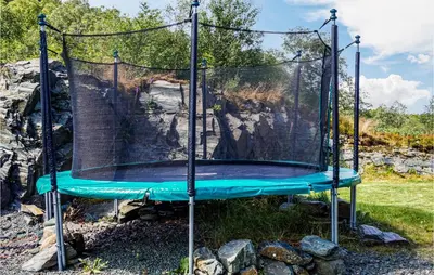 a blue trampoline with a net on it at Nice Home In Lundegrend With Wifi in Grimsland
