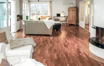 a living room with a couch and wooden floors at Nice Home In Lundegrend With Wifi in Grimsland