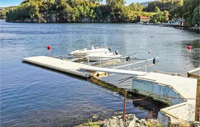 a dock with two boats in a body of water at Nice Home In Lundegrend With Wifi in Grimsland