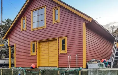a red and yellow house with a yellow door at Holiday Home Finnås Lyklingsjøvegen in Vinnes