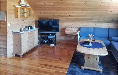 a living room with a blue couch and a tv at Holiday Home Finnås Lyklingsjøvegen in Vinnes
