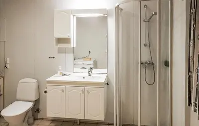 a bathroom with a toilet and a sink and a shower at Holiday Home Finnås Lyklingsjøvegen in Vinnes