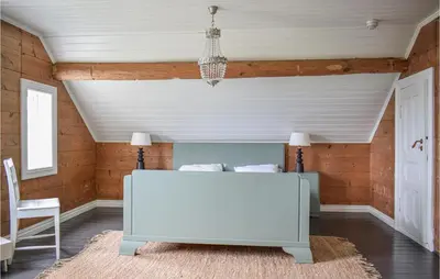 a bedroom with a white bed and a chandelier at Holiday Home Finnås Lykling in Vinnes