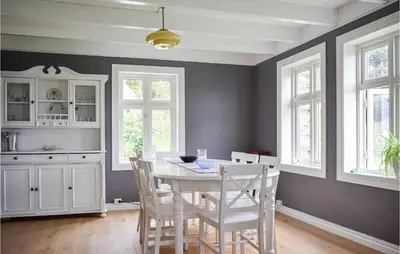 a dining room with a white table and chairs at Holiday Home Finnås Lykling in Vinnes