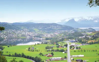 a town on a hill with a lake and mountains at Cozy Home In Norheimsund in Norheimsund