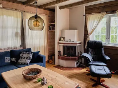 a living room with a blue couch and a table at Nice apartment in Trysil ski in-out, sauna and view in Trysil