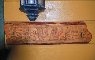 a wooden sign on a wall with a clock on it at Nice Apartment In Rosendal With Sauna in Rosendal