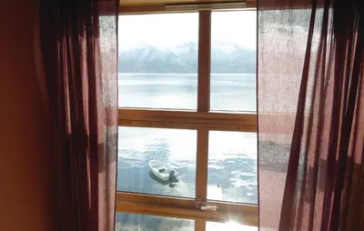 a window with a view of a boat in the water at Cozy Apartment In Rosendal With Sauna in Rosendal