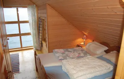 a bedroom with a bed in a wooden cabin at Cozy Apartment In Rosendal With Sauna in Rosendal