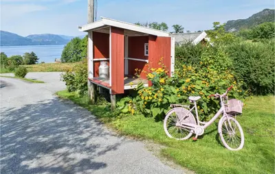 a bike parked in the grass next to a house at Eikhaugen Gjestegard in Husa