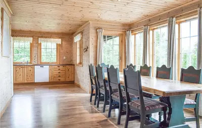a dining room with a wooden table and chairs at Eikhaugen Gjestegard in Husa