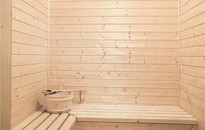 a sauna with a tub and a bucket at Eikhaugen Gjestegard in Husa