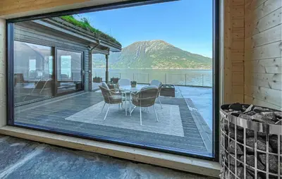 a dining room with a table and chairs on a balcony at Raaen Hytteutleige in Utne