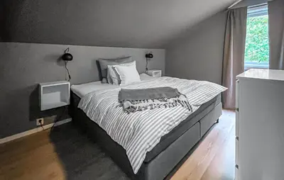 a bedroom with a large bed with a striped blanket at Raaen Hytteutleige in Utne