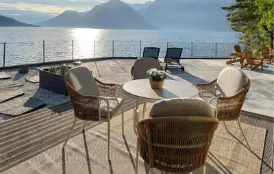 a table and chairs on a deck with a view of the water at Raaen Hytteutleige in Utne