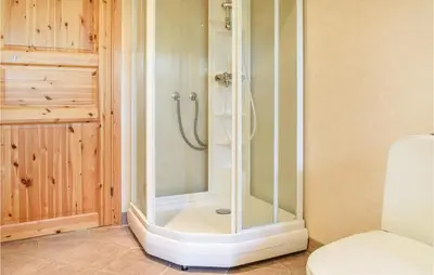 a shower with a glass door in a bathroom at Eikhaugen Gjestegard in Husa