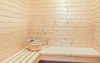 a small wooden sauna with a bucket in it at Eikhaugen Gjestegard in Husa