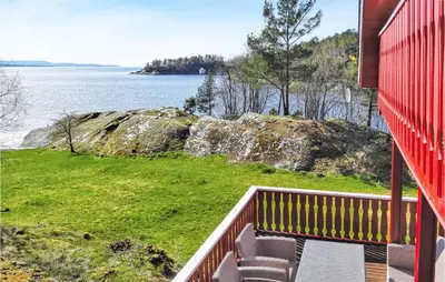 a balcony of a house with a view of the water at Amazing Home In Nordtveitgrend in Hjartåker