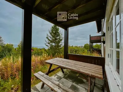 a wooden bench sitting on the porch of a house at Great apartment in Trysil, ski inout, wifi, sauna in Trysil