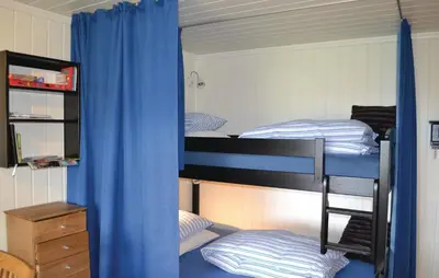 a bedroom with two bunk beds with blue curtains at Cozy Apartment In Norheimsund With Wifi in Norheimsund