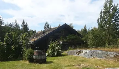 a log cabin with a barrel in front of it at Fredelig plass for rekreasjon in Krøderen