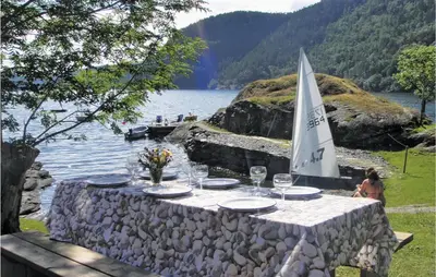 a table with glasses and a sail boat on a lake at Beautiful Home In Nordtveitgrend in Haugen