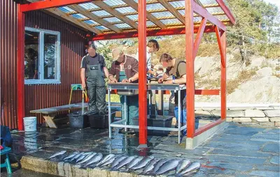 a group of men standing around a table with fish at Nice Home In Hatlestrand in Hatlestrand