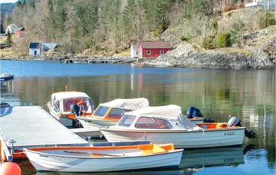 three boats are docked at a dock in the water at Nice Home In Hatlestrand in Hatlestrand