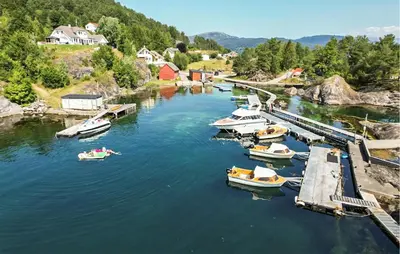a group of boats are docked in a river at Nice Home In Hatlestrand in Hatlestrand