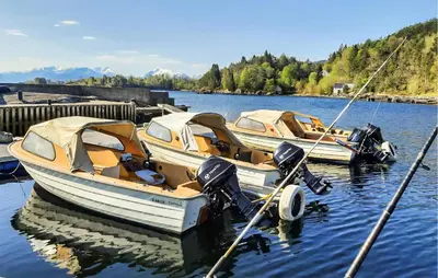 two boats are docked at a dock in the water at Nice Home In Hatlestrand in Hatlestrand